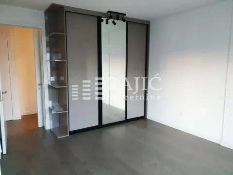 Bedroom with a large built-in wardrobe and wooden flooring. - image 6