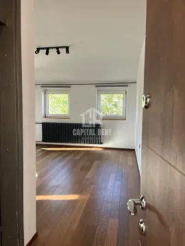 Empty room with wooden flooring, white walls, and two windows. - image 13