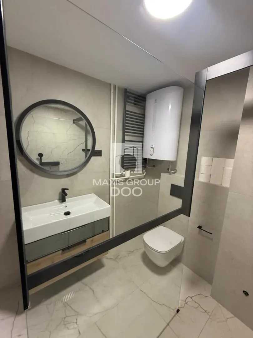 Modern bathroom equipped with a washbasin, mirror, and toilet bowl.