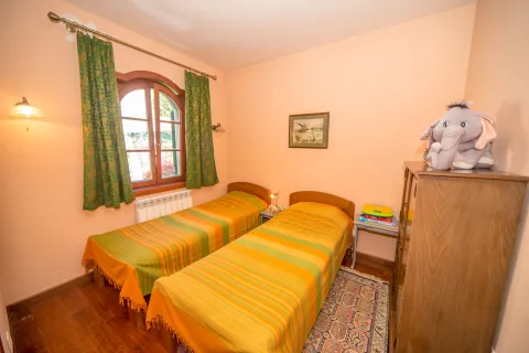 Spavaća soba sa dva kreveta za jednu osobu, drvenim ormarom i prozorom. - image 10