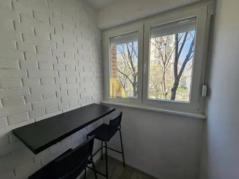 Zastakljeni balkon sa šankom, stolicama i belim ciglama na zidu. - image 9