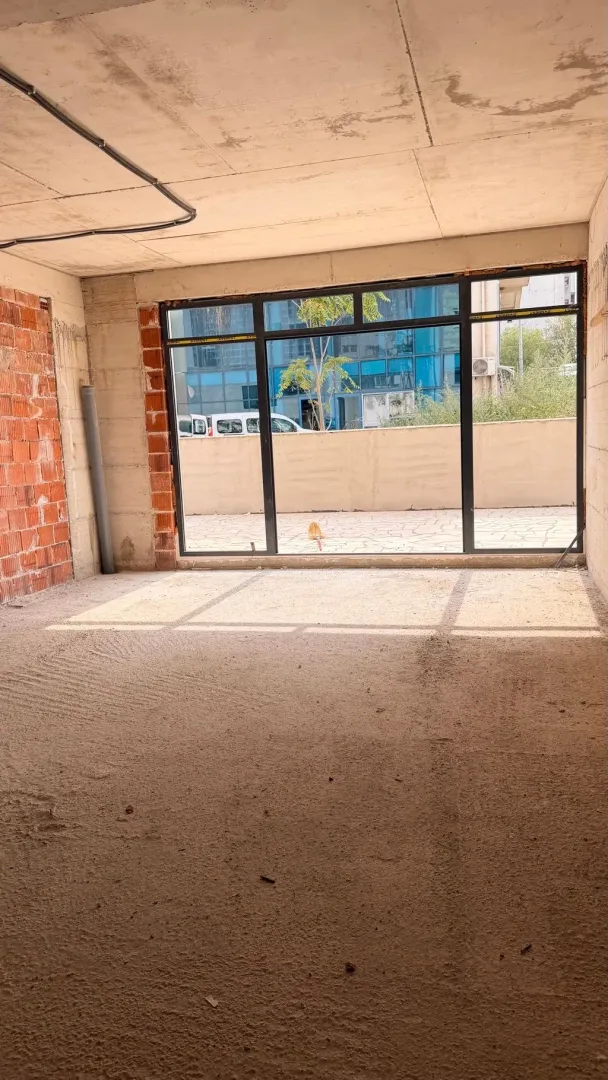 Unfinished room under construction with a large window and a view of the terrace.