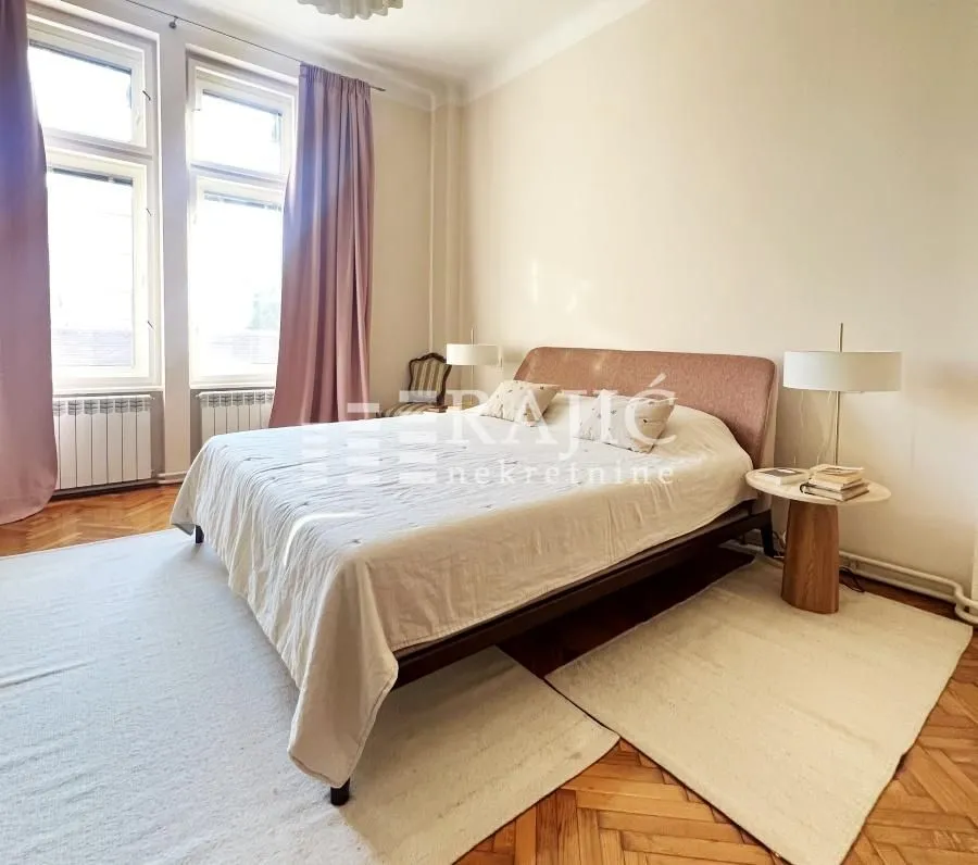 Bedroom with a double bed, lamps, and windows.