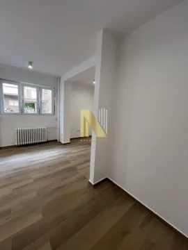 Empty living room with wooden flooring and white walls. - image 4