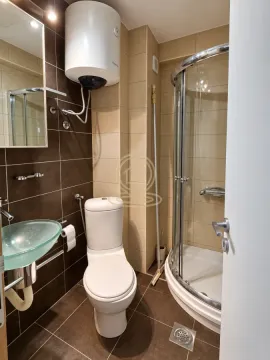 Bathroom equipped with a shower cabin, washbasin, toilet, and water heater. - image 14