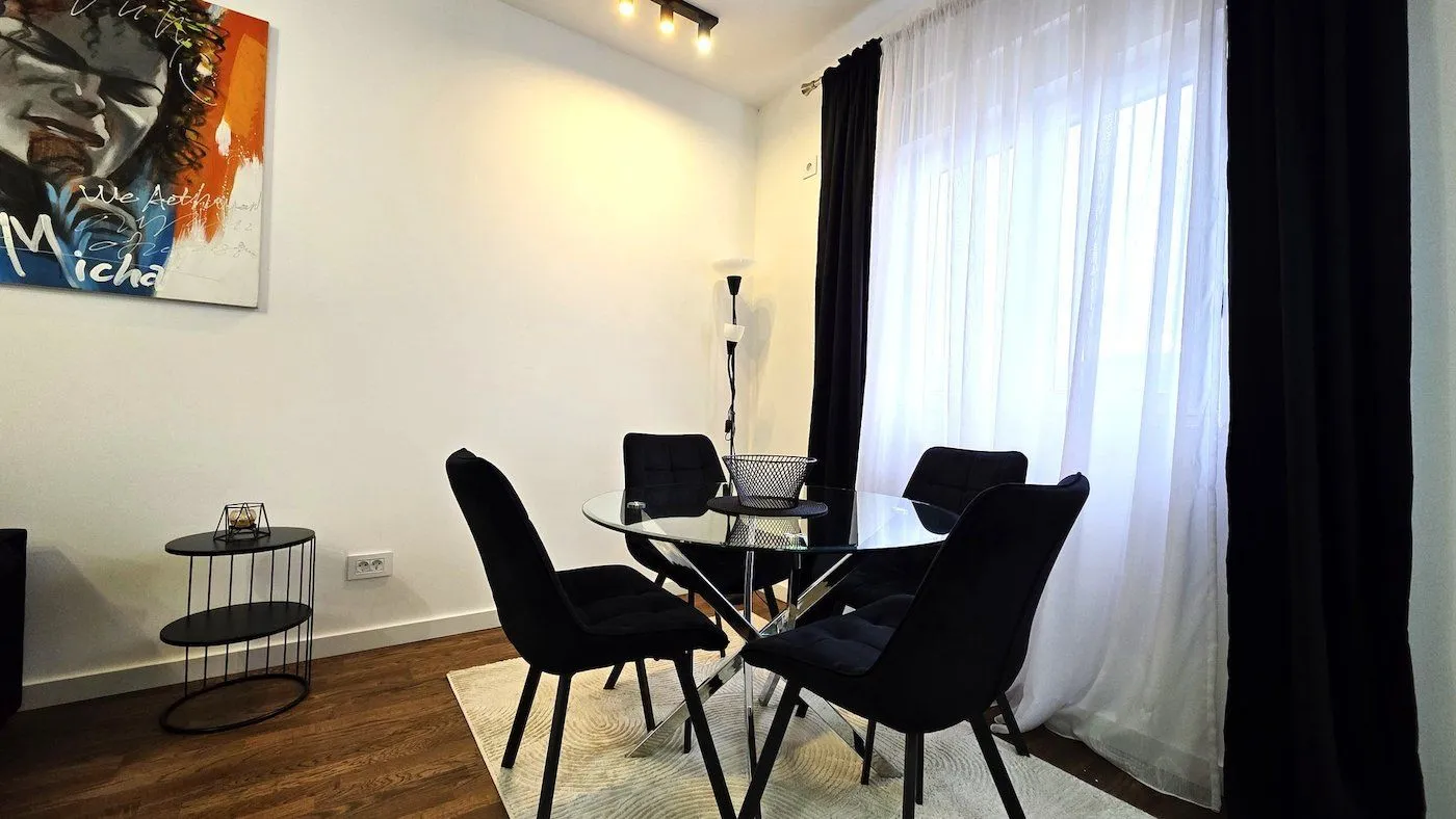 Dining area with a glass table and black chairs.