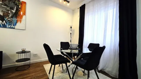Dining area with a glass table and black chairs. - image 4