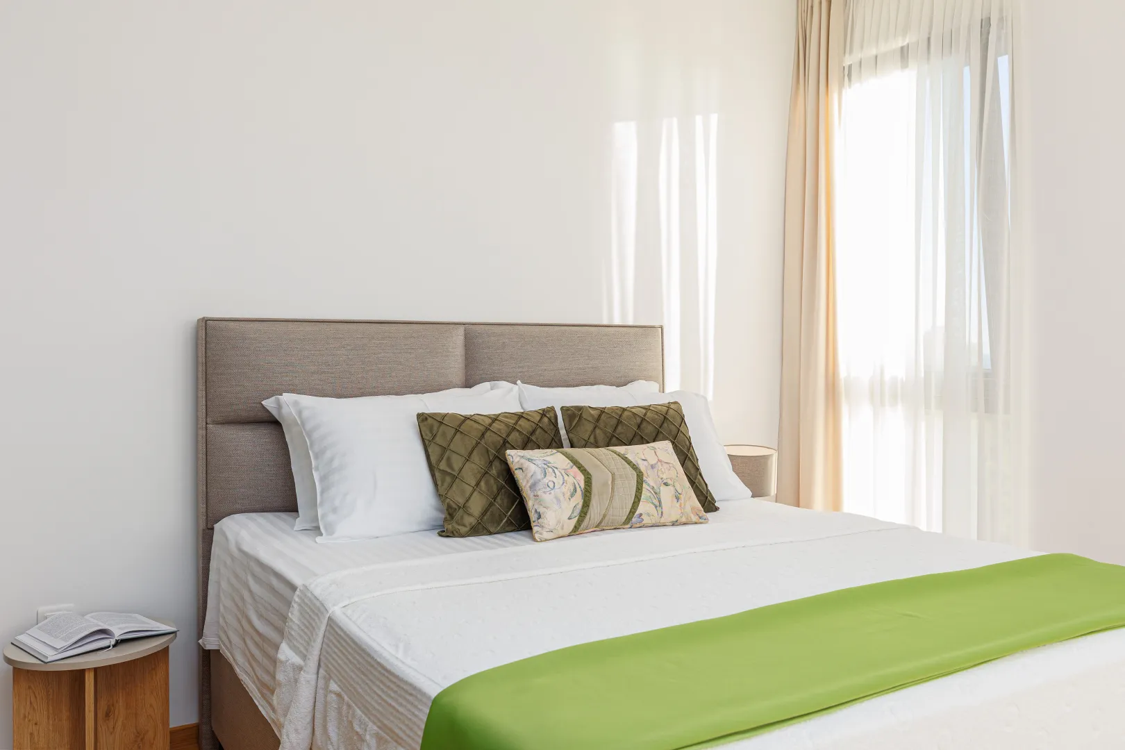 A comfortable bedroom with a double bed and a window covered with curtains.