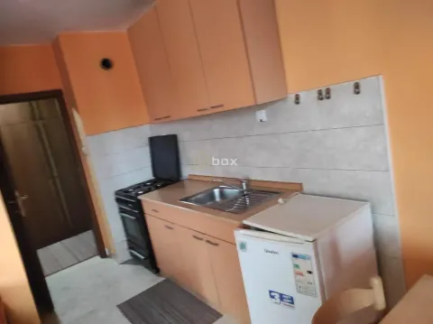 Manja kuhinja sa elementima u boji drveta i osnovnim kućnim aparatima. - image 3