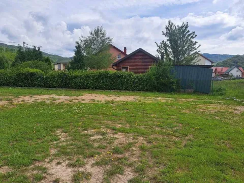Travnati plac sa kućama u pozadini okružen zelenilom. - image 5