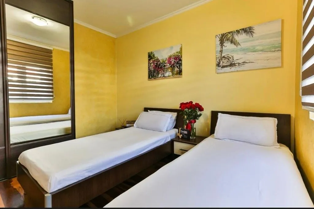 Bedroom with two single beds and a mirrored wardrobe.