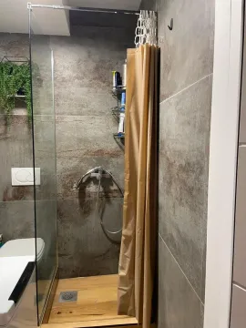 Modern bathroom with a walk-in shower and grey tiles. - image 4