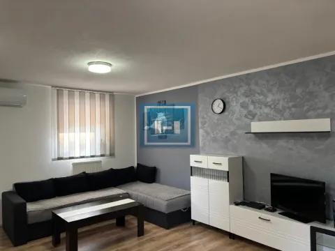 Dnevna soba sa ugaonom garniturom, stočićem i televizorom na zidu. - image 3