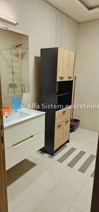 Kupatilo sa umivaonikom, ogledalom i ormarićem.