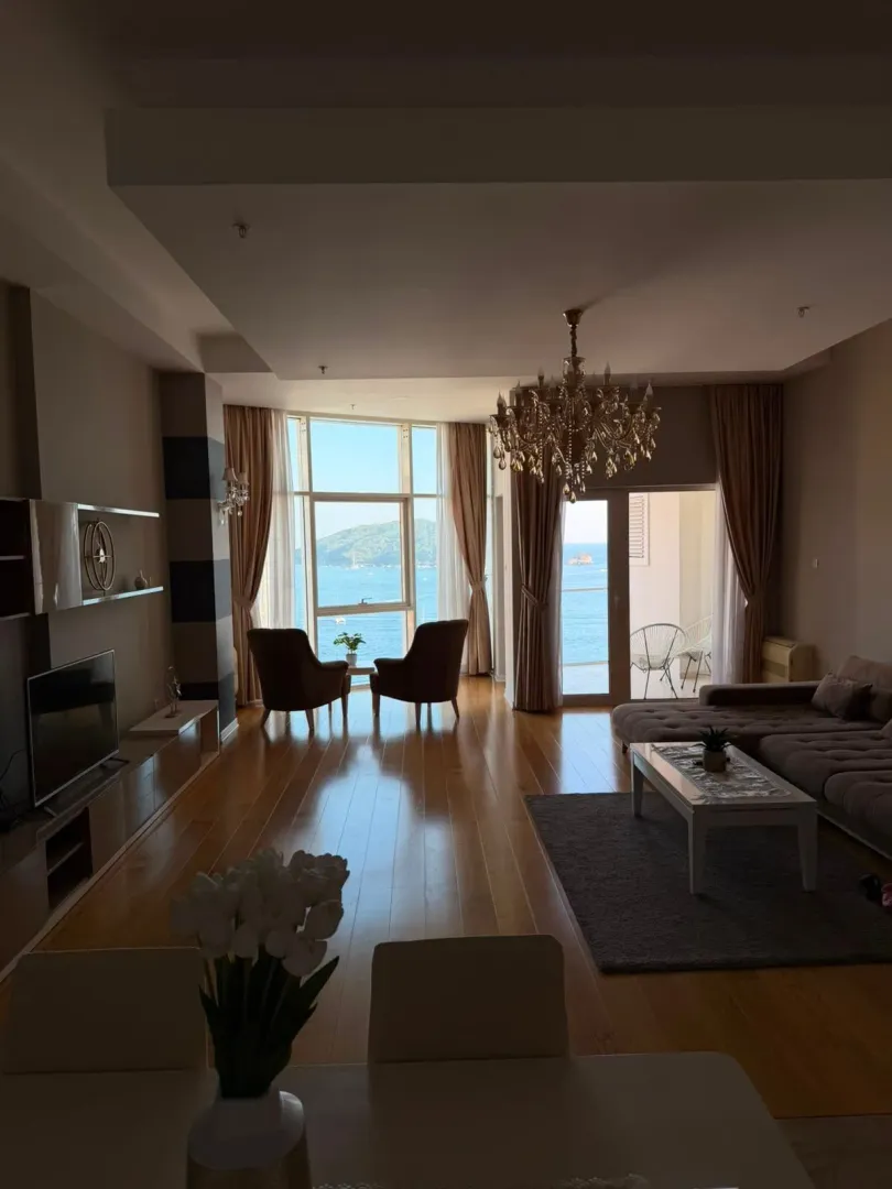 Spacious living room with a sofa set, dining area, and sea view.