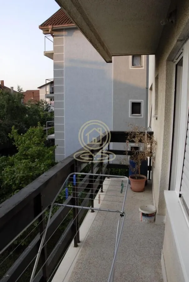 Balkon sa drvenom ogradom i sušačem za veš.