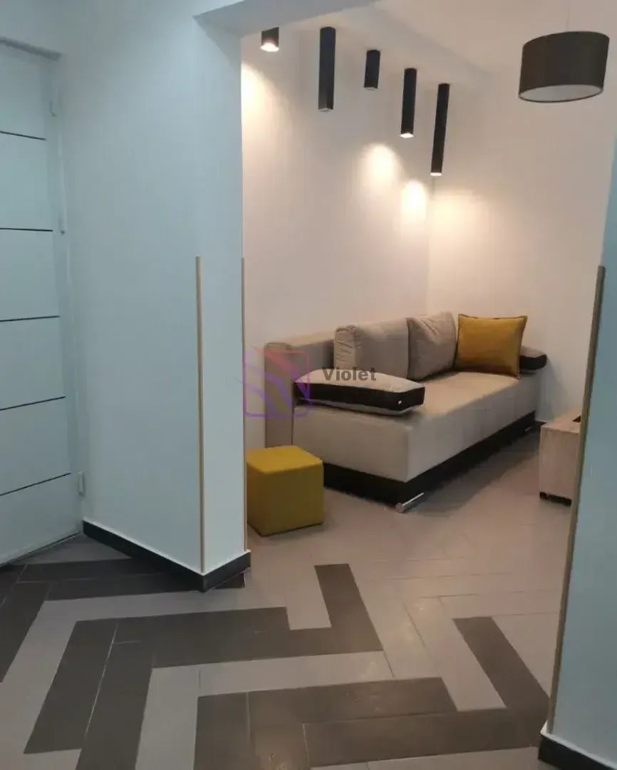 Dnevni boravak sa sjedećom garniturom i modernom rasvjetom.