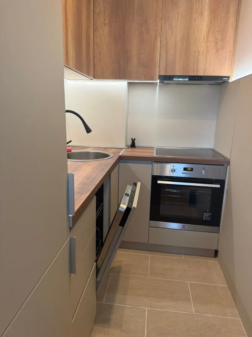 Smaller equipped kitchen with wooden elements and built-in appliances.