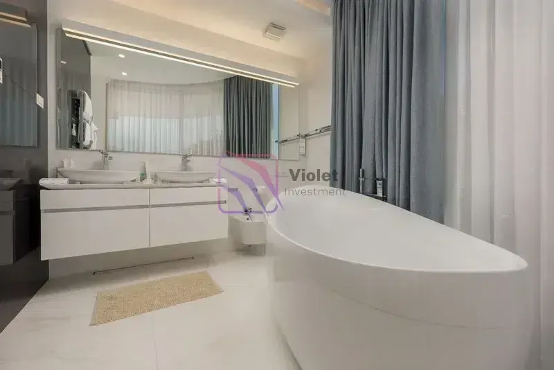 Moderne kupatilo sa kadom, dvostrukim umivaonikom i velikim ogledalom.