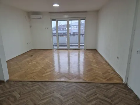 Empty room with parquet flooring and large balcony doors. - image 3