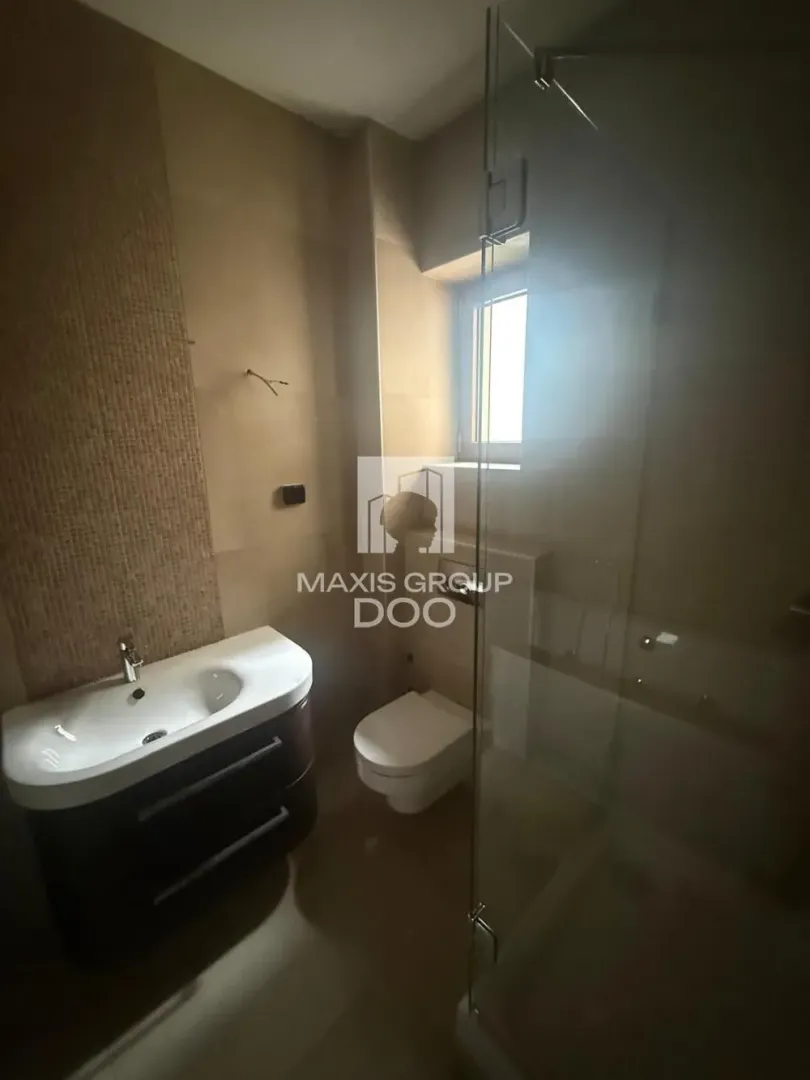 Clear bathroom with a vanity, toilet, and walk-in shower.