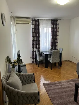 Svijetao dnevni boravak sa trpezarijskim stolom i drvenim parketom. - image 2