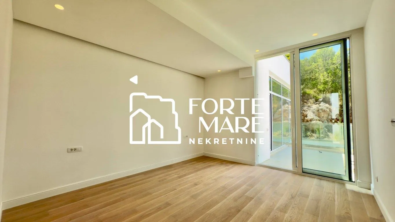Empty room with wooden flooring and access to the terrace.