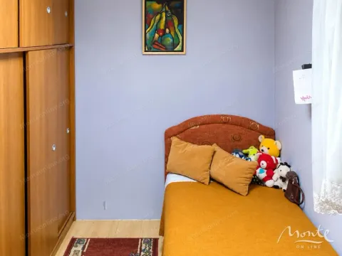Small bedroom with a bed and a wooden wardrobe. - image 6