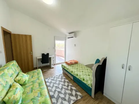 Namještena spavaća soba sa krevetom, garderoberom i izlazom na terasu. - image 9