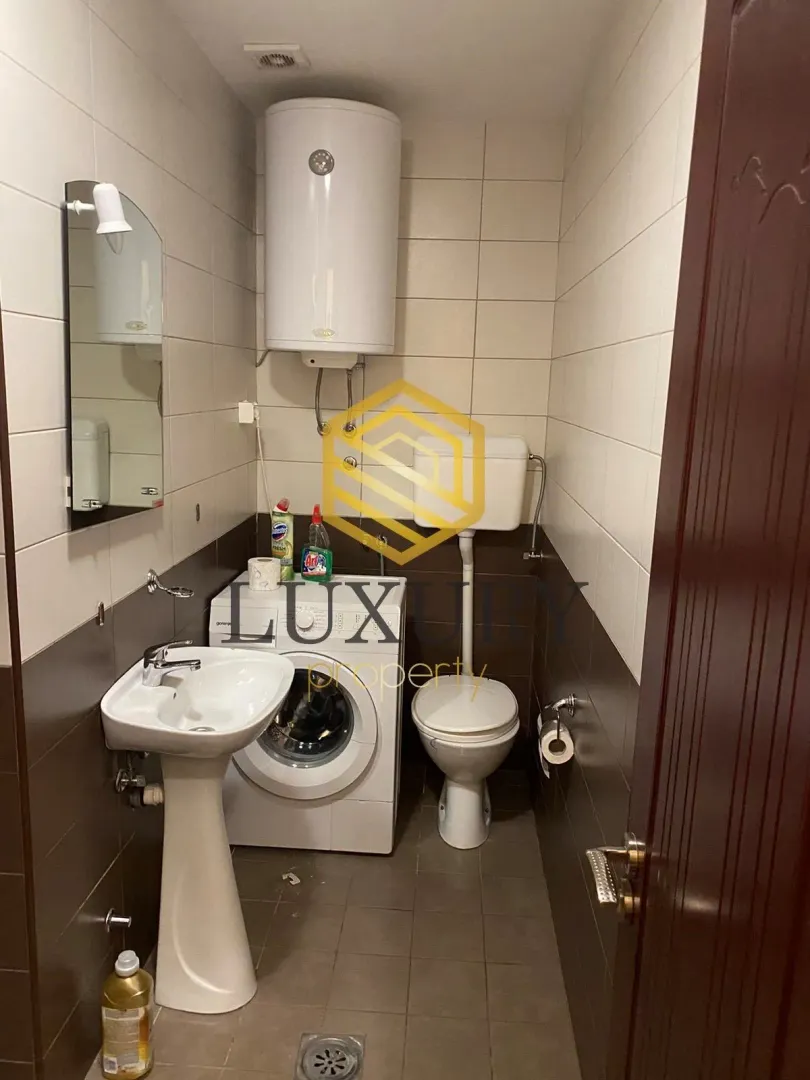 Small bathroom with a sink, toilet, and washing machine.