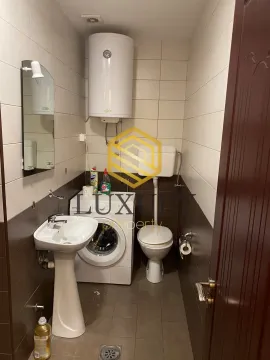Small bathroom with a sink, toilet, and washing machine. - image 4