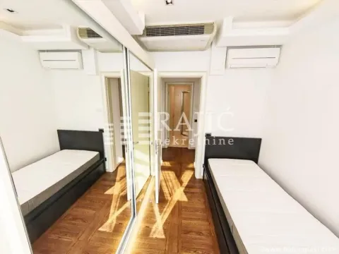 Smaller bedroom with two single beds and a mirrored built-in wardrobe. - image 8
