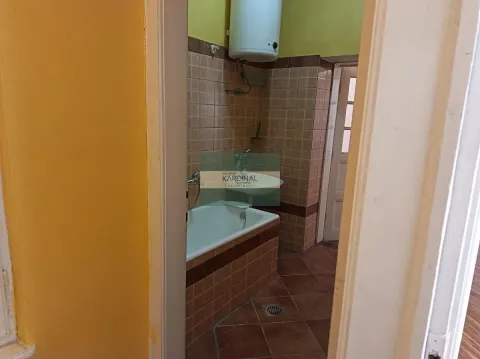 Pogled na kupatilo obloženo keramičkim pločicama sa kadom i bojlerom. - image 12