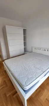 Svijetla spavaća soba sa bijelim krevetom i ormarom. - image 13