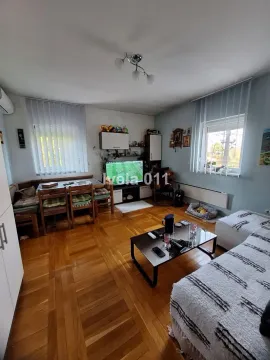 Dnevna soba sa garniturom, trpezarijskim stolom i parketom na podu. - image 2