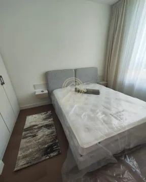 Bedroom with a double bed covered in protective film. - image 9