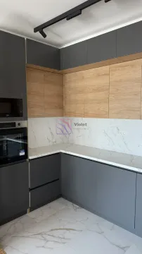Moderna ugaona kuhinja sa sivim i drvenim elementima. - image 6