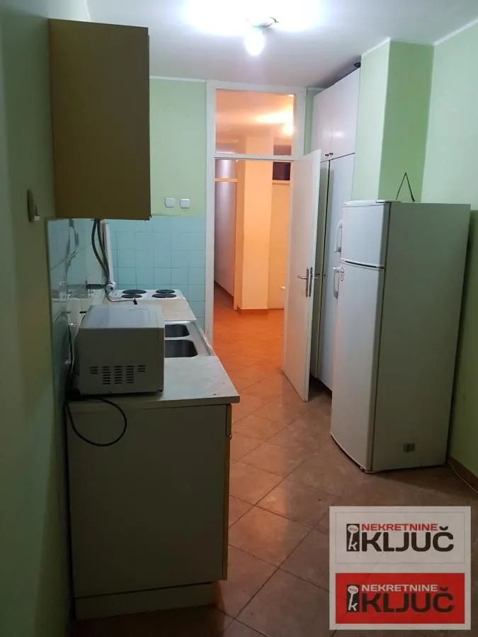 Manja kuhinja sa sudoperom, štednjakom i frižiderom.