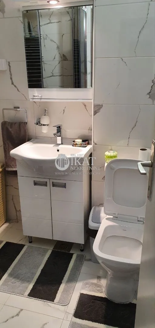 Small bathroom with a washbasin, mirror, and toilet.