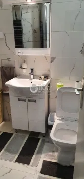 Small bathroom with a washbasin, mirror, and toilet. - image 17