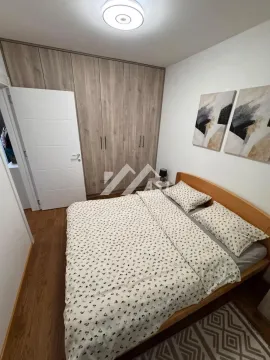 Nameštena spavaća soba sa bračnim krevetom, velikim garderoberom i slikama na zidu. - image 6