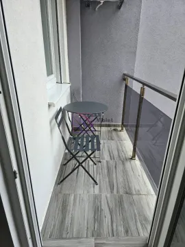 Small furnished balcony with a table and two chairs. - image 7