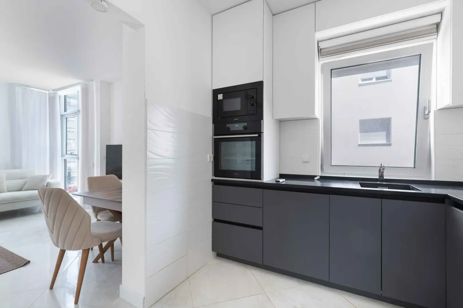 Modern kitchen with dark cabinetry and a view of the dining area.