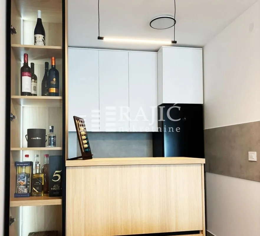 Modern kitchen with a bar counter and built-in units.