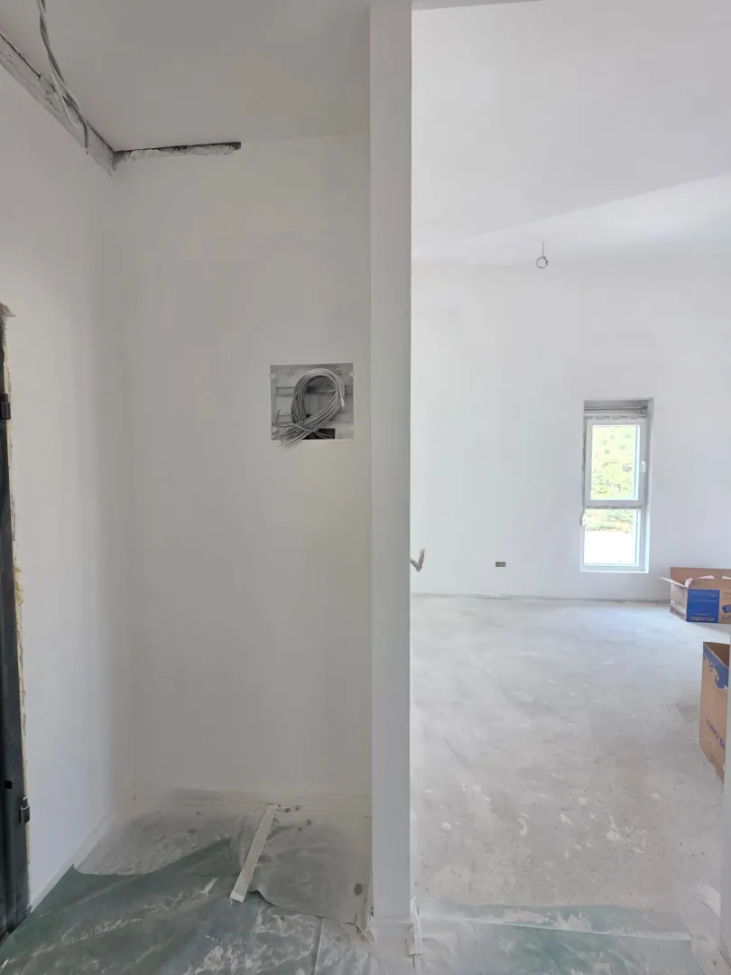 Empty room under renovation with white walls.