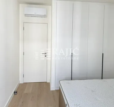 Bedroom with built-in wardrobe, bed, and air conditioning. - image 11