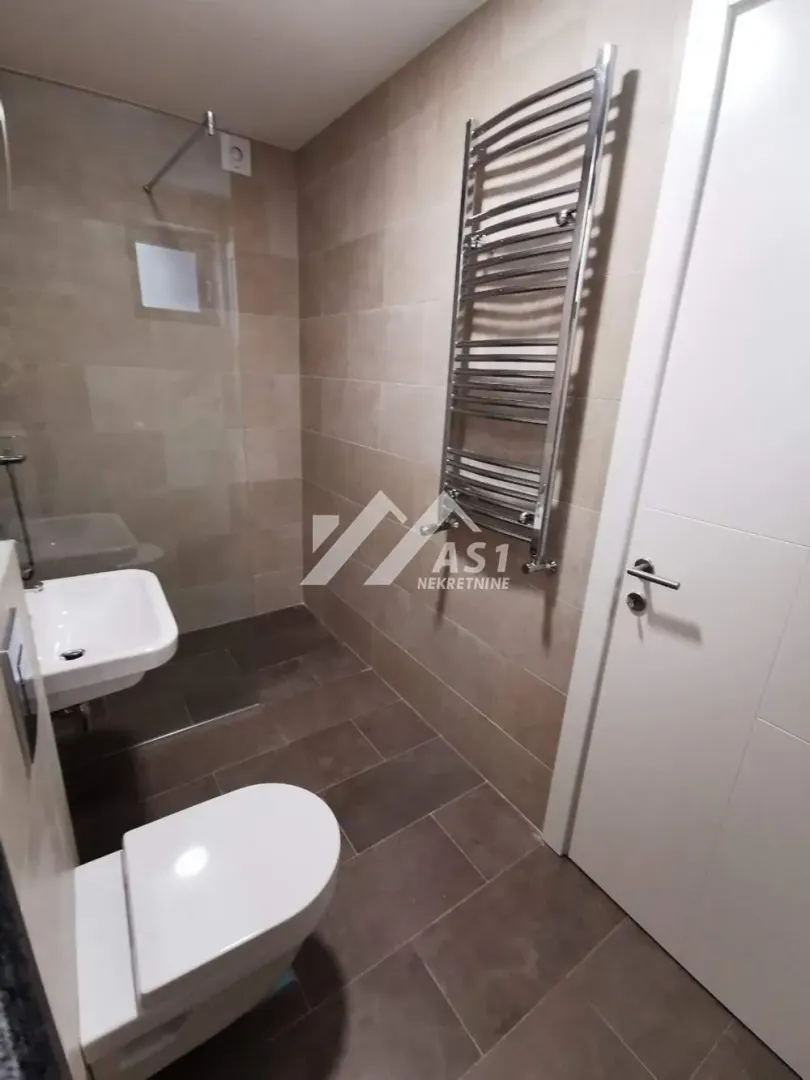 Manje kupatilo sa tuš kabinom, umivaonikom i WC šoljom.