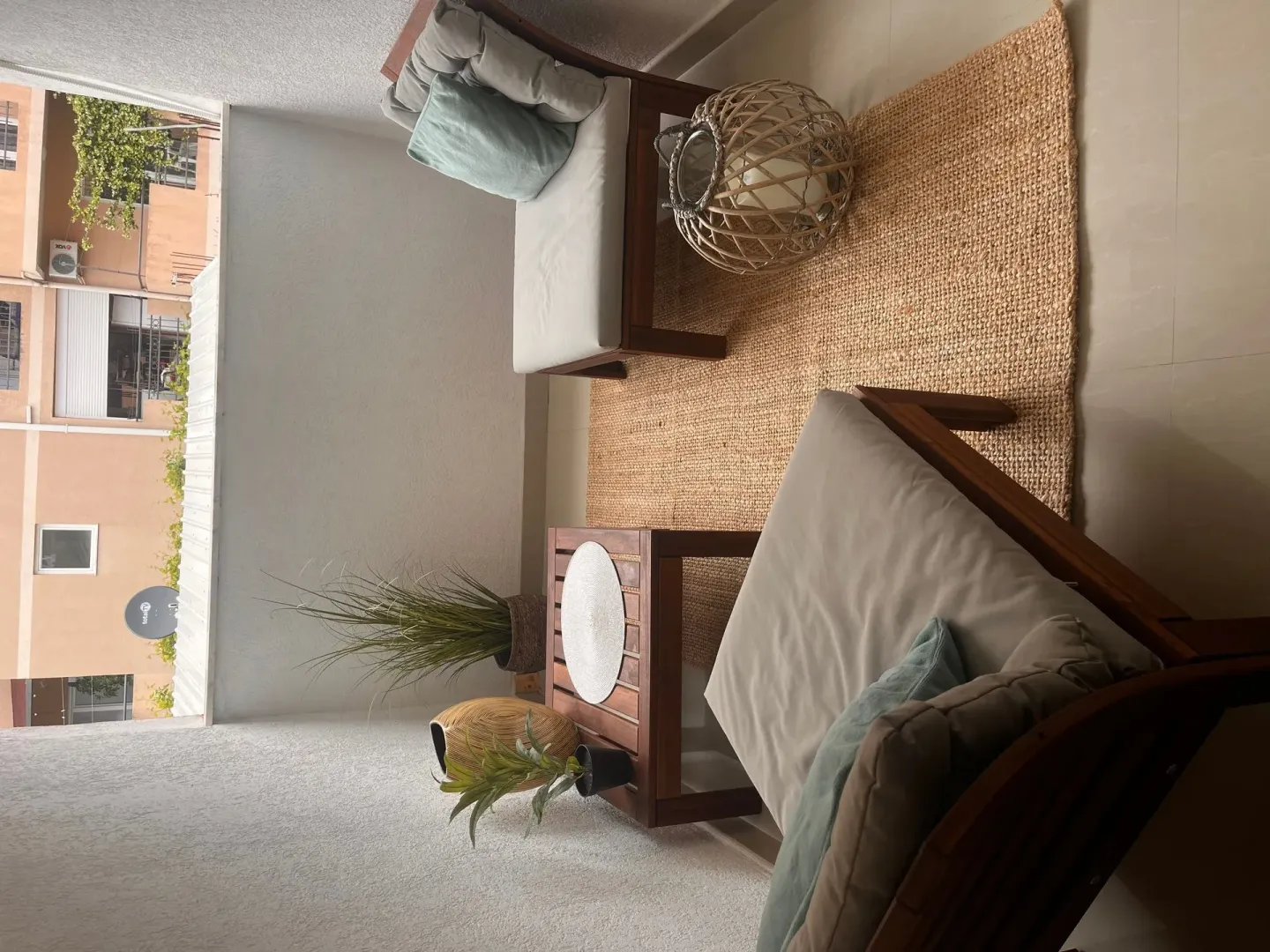 Namješten balkon sa garniturom za sjedenje i dekorativnim detaljima.