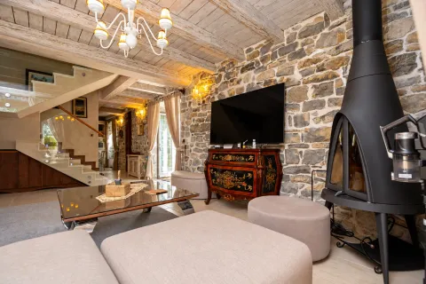 Living room with a fireplace, stone wall, and wooden ceiling. - image 3
