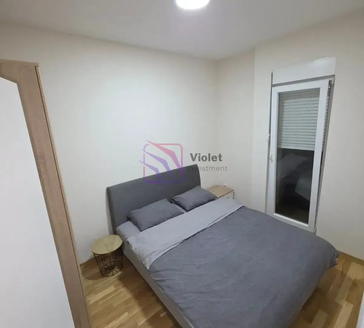 Smaller bedroom with a double bed and parquet flooring.